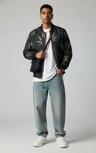 Load image into Gallery viewer, Man wearing a black bomber jacket with colorful patterns, white t-shirt, light blue jeans, and white sneakers on a plain background.