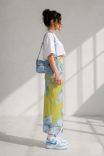 Load image into Gallery viewer, A person wearing a white crop top, a floral pint pencil skirt in a bright room.
