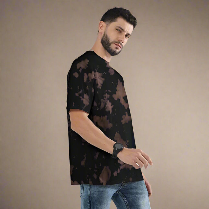 Man wearing a black tie-dye t-shirt and jeans on a white background