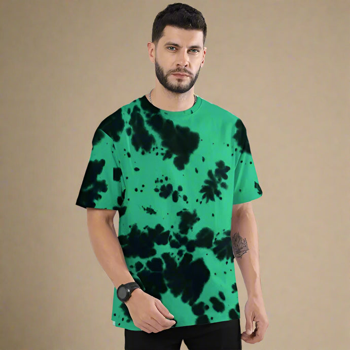 Man wearing a green t-shirt with black abstract patterns on a white background