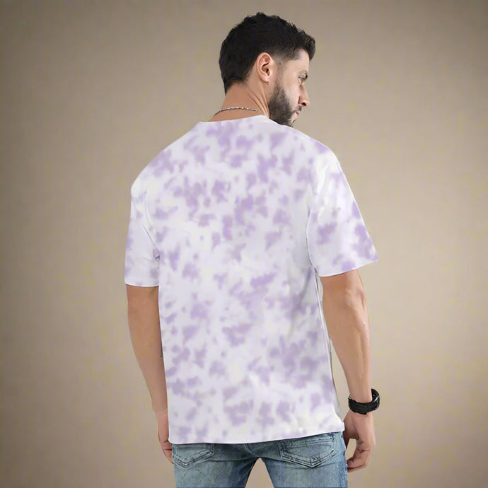 Man wearing a white t-shirt with purple tie-dye pattern on a plain background